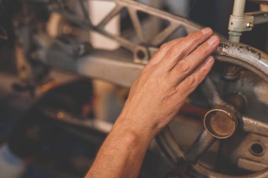 Yaşlı adamın elini bir fabrika makine