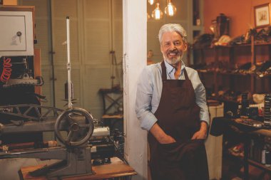 Atölye üniformalı gülümseyen yaşlı Ayakkabıcılık