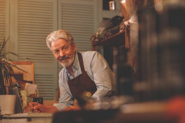 Studio üniformalı yaşlı bir kunduracı