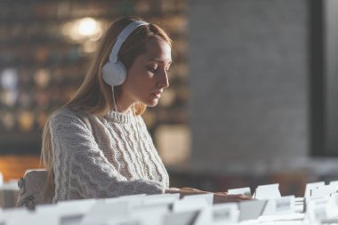 Kayıtları bir müzik mağazası tarama çekici genç kız