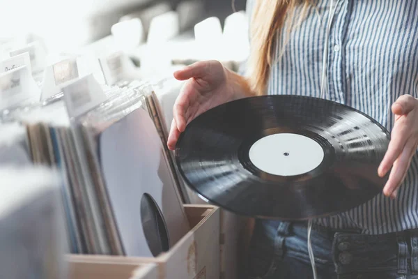 Young woman with music records in a store