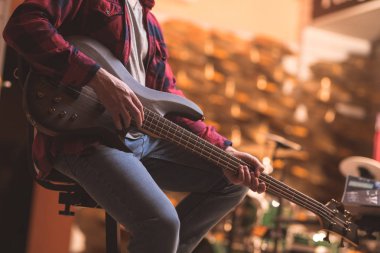 Genç müzisyen kapalı bas gitar çalmaya