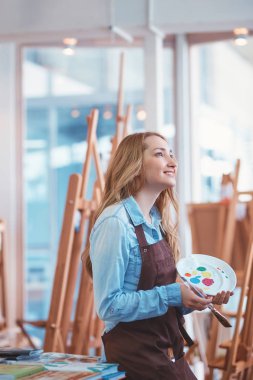 Studio işyerinde gülümseyen çekici sanatçı