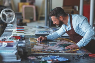 Mozaikte çalışan adam stüdyoda.