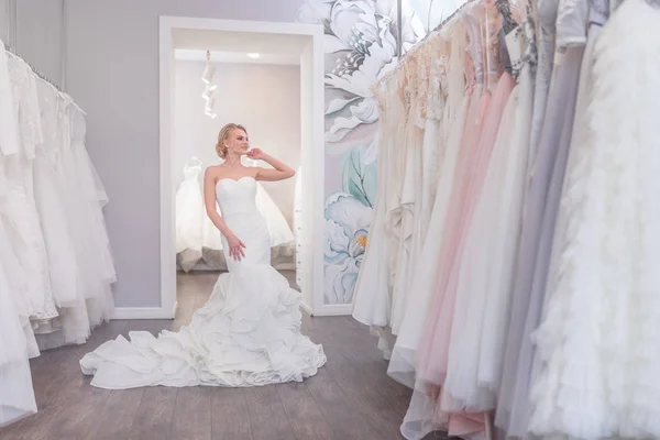 Attractive woman in a wedding dress in the store