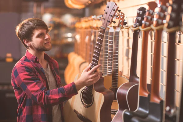 Молодий Чоловік Вибирає Гітару Музичному Магазині — стокове фото