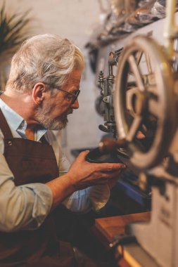 Stüdyoda iş yerinde yaşlı bir kunduracı