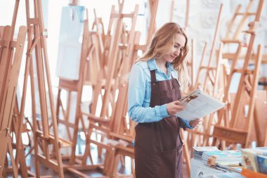 Sephalar arka plan üzerinde apronda genç sanatçı