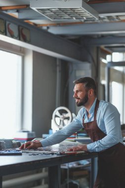 Stüdyoda üniformalı, olgun bir adam çalışıyor.