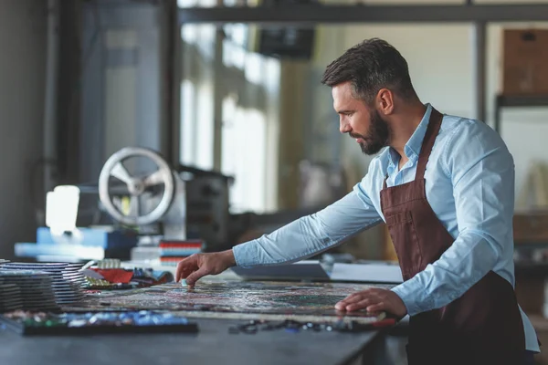 Stüdyoda üniformalı, olgun bir adam çalışıyor.