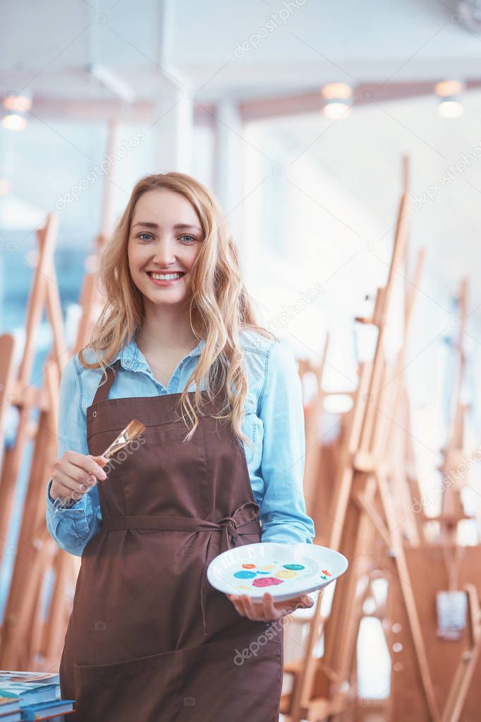 Smiling artist with a palette in the art store