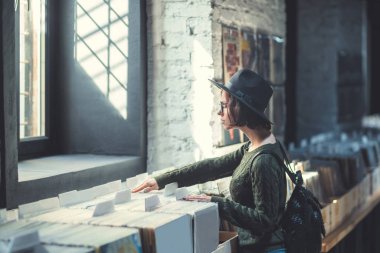Genç kız vinil kayıtlar bir müzik mağazası tarama