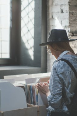 Çekici kız bir müzik mağazası vinil kayıtlar tarama