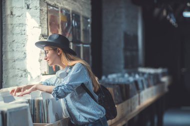 Genç kız vinil kayıtlar bir müzik mağazası tarama