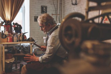 Yaşlı bir kunduracı bir atölye çalışmalarında