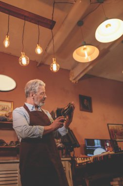 Üniformalı bir ayakkabı kapalı ile yaşlı bir kunduracı