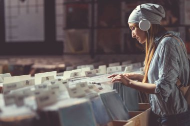 Çekici kız bir müzik mağazası kulaklıklar müzik dinlemek