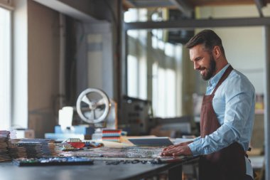 Mozaik atölye ile gülümseyen olgun adam