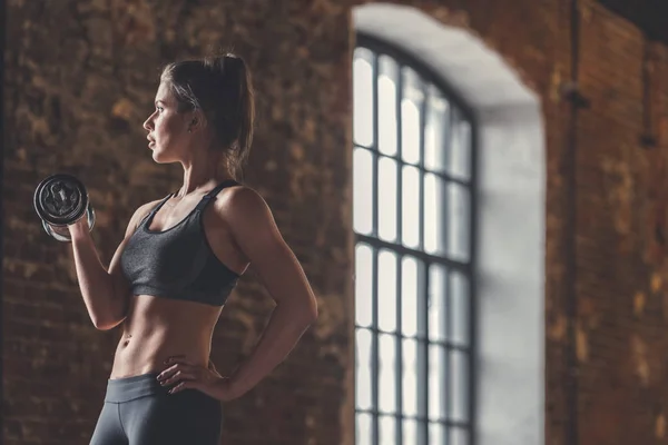 Athletische Junge Frau Mit Hantel Auf Dem Dachboden — Stockfoto