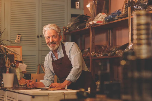 Studio üniformalı gülümseyen yaşlı Ayakkabıcılık