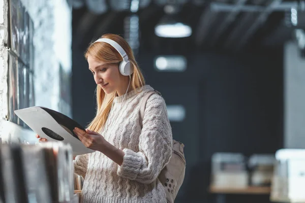 Attractive woman with headphones in a record store