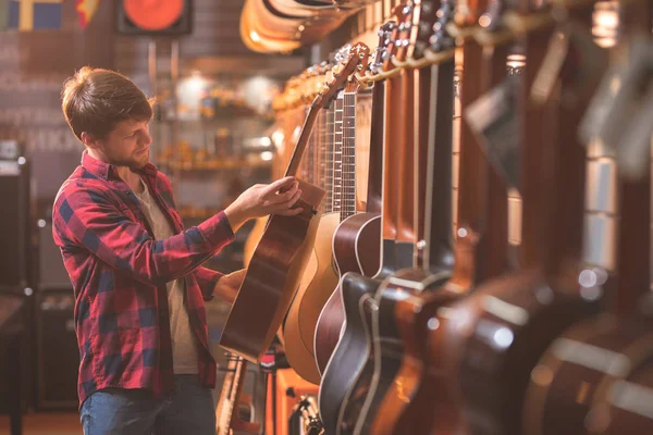 Giovane Uomo Che Sceglie Una Chitarra Casa — Foto Stock