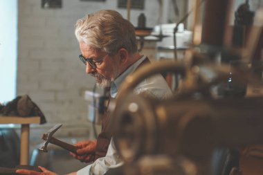 Yaşlı bir kunduracı bir atölye çalışmalarında
