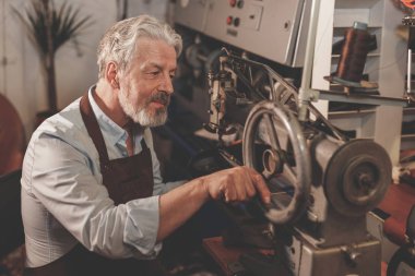 İş yerinde üniformalı gülümseyen yaşlı adam