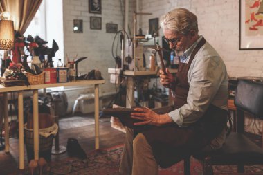 İş yerinde apronda yaşlı bir kunduracı