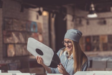 Bir kaydı bir müzik mağazası ile gülümseyen kadın