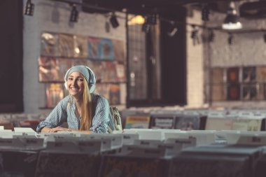 Bir vinil mağaza kulaklıklar ile gülümseyen kadın