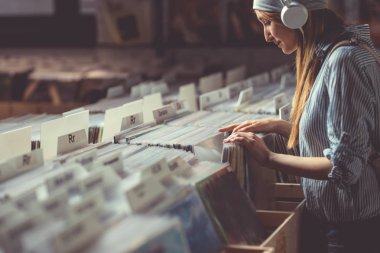 Bir vinil mağaza kulaklıklar ile çekici kız