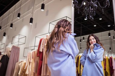 Aynaya bir mağaza, paltolu güzel kadın