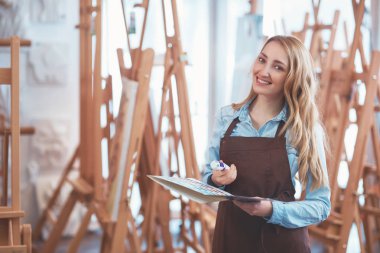 Gülümseyen sanat depodaki üniformalı çekici kadın