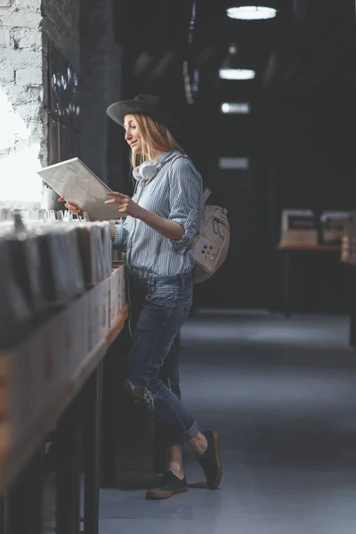 音楽ストア内のレコードを持つ若い女性 — ストック写真