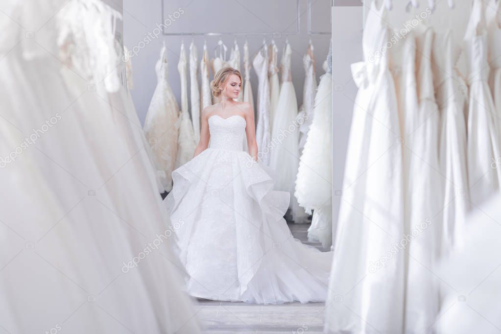 Beautiful woman in a white dress in wedding shop
