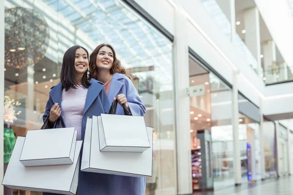 微笑的年轻妇女与购物袋在商店 — 图库照片