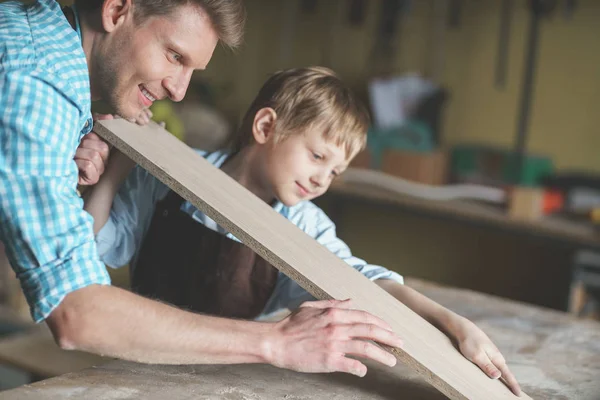 Baba ve oğul marangozluk bir yönetim kurulu ile gülümseyen