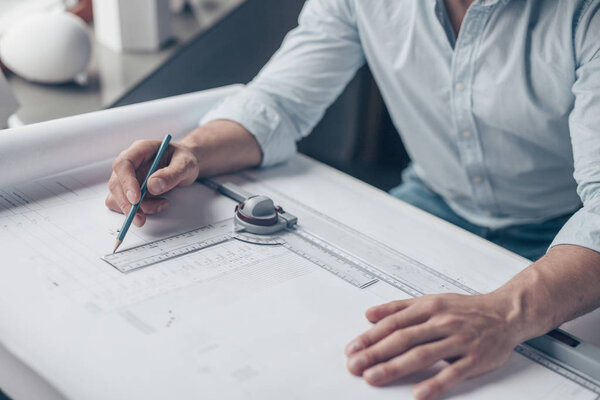 Men's hands with architectural tools at work