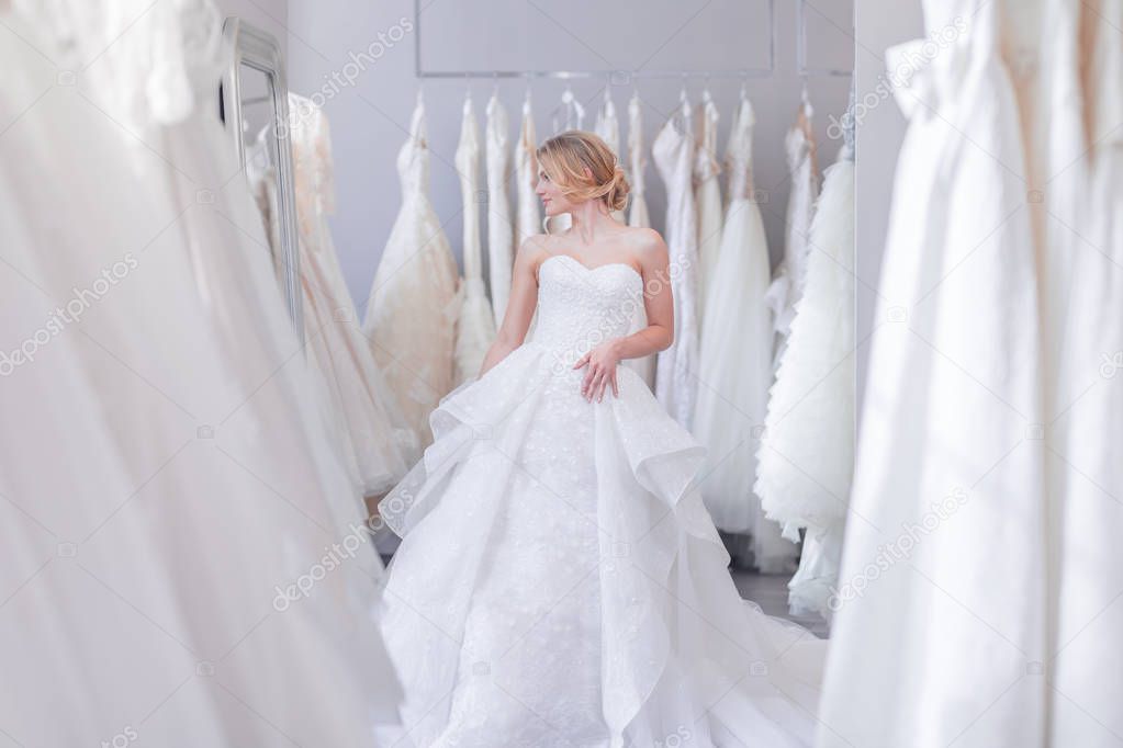 Beautiful bride in wedding dress in the store