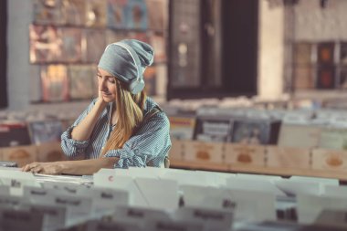 Kulaklıklar müzik mağazası ile gülümseyen genç kadın