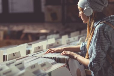 Kulaklıklar müzik mağazası ile genç çekici kadın