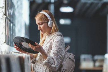 Kulaklıklar müzik mağazası ile genç çekici kız