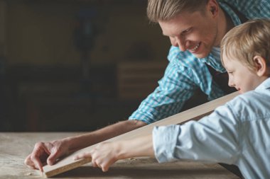 Gülümseyen baba ve küçük oğlu marangozluk sonra işte