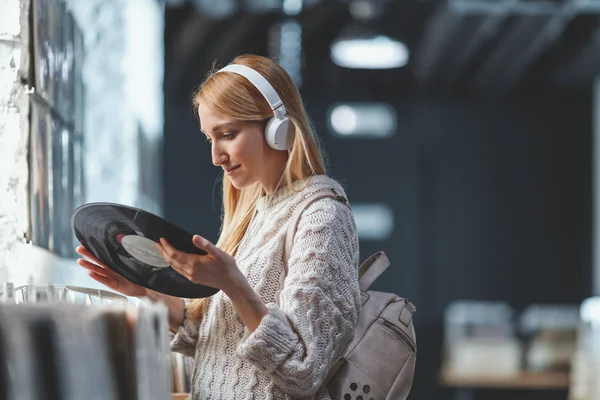 Kulaklıklar müzik mağazası ile genç çekici kız