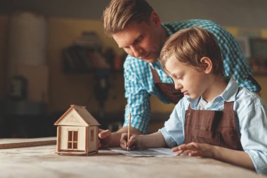 Genç marangozluk ahşap bir evde ailesiyle