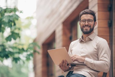 Dizüstü bilgisayar açık havada Genç adamla gülümseyen