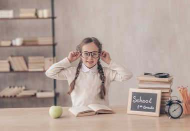 Studio masasında gülümseyen küçük kız