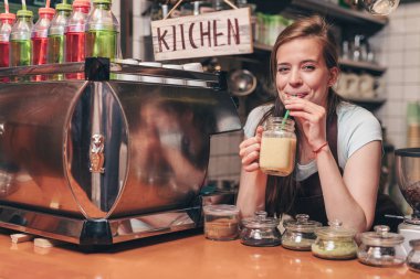 Genç kadın mutfakta smoothies içme