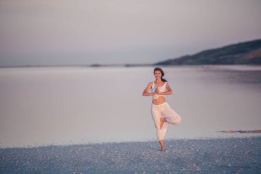 Çekici kadın batımında Yoga uygulamak